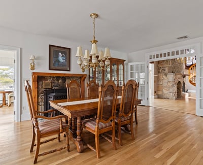 Spacious dining area features a classic table set, surrounded by natural light and detailed woodwork throughout.