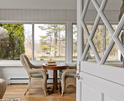 Inviting sunlit space featuring expansive windows and cozy seating, perfect for relaxation and gatherings.