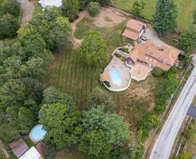 Sprawling property with two pools, vibrant greenery, and ample space for outdoor activities and relaxation.