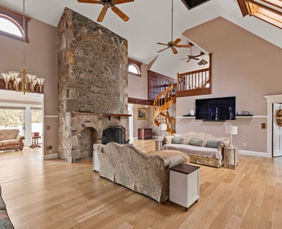 Spacious living area featuring a dramatic stone fireplace and a cozy open layout. Perfect for gatherings.