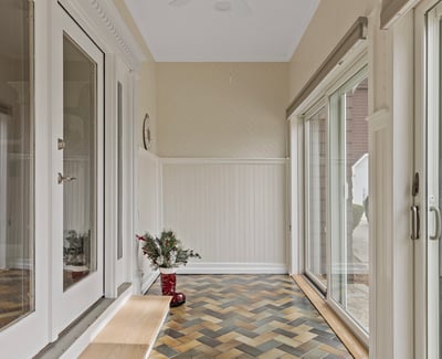 Bright entryway featuring unique herringbone floors, large windows, and ample natural light, ideal for welcoming guests.