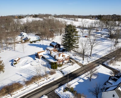 Spacious homes on expansive snowy lots, surrounded by trees and tranquil countryside views, perfect for peaceful living.