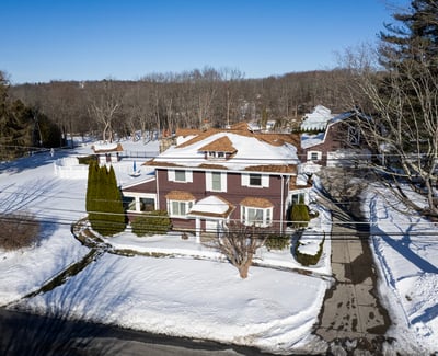 Spacious home on a large lot, featuring expansive outdoor areas and nearby wooded surroundings.