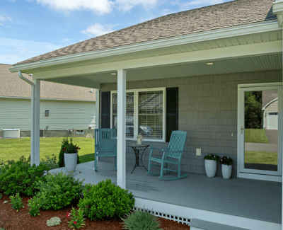 Inviting porch setup with greenery and seating, perfect for enjoying morning coffee in a quiet neighborhood.