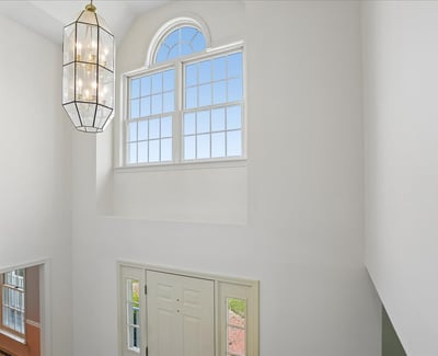 Expansive entryway featuring a statement light fixture and large windows that invite natural light.