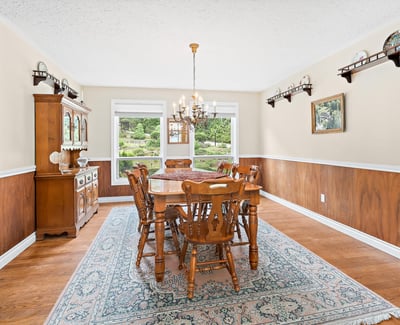 Expansive dining room featuring warm wood accents and large windows overlooking a picturesque outdoor view.