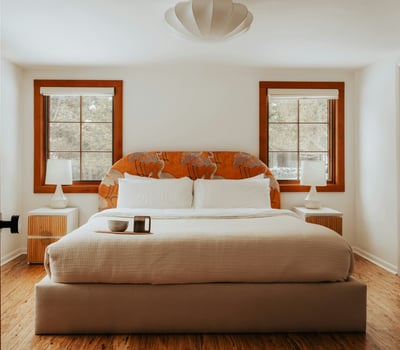Bright and inviting bedroom features natural light, unique headboard, and a cozy atmosphere for restful nights.