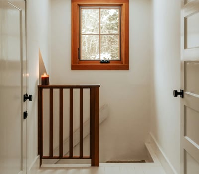 Bright and inviting hallway featuring natural light, wood accents, and a cozy atmosphere.