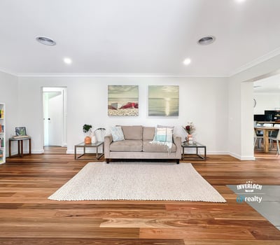 Bright and spacious living area featuring warm wooden floors, modern artwork, and an inviting atmosphere.