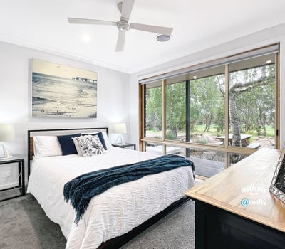 Bright bedroom with large windows offering scenic views and modern finishes for comfortable living.