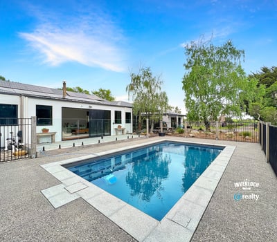This contemporary home features a spacious outdoor area with a pristine pool and landscaped surroundings.