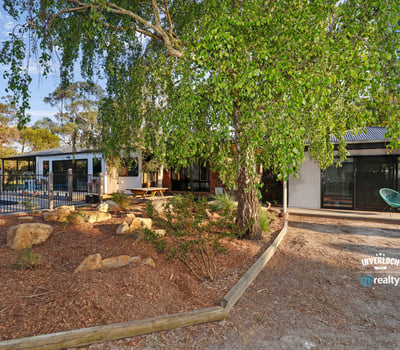 Contemporary home surrounded by lush landscaping, featuring spacious outdoor areas and modern design elements.