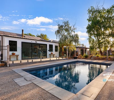 Discover a modern home featuring an inviting outdoor pool and spacious patio, perfect for entertaining.