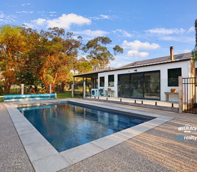 Contemporary home featuring an inviting pool area, surrounded by lush landscaping and ample outdoor space for relaxation.