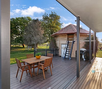 Spacious outdoor deck with direct access to lush greenery, ideal for entertaining and relaxation.