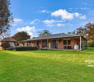 Spacious home set on expansive grounds, featuring large windows and a seamless indoor-outdoor living experience.