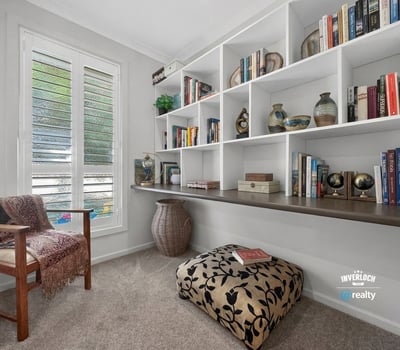 This inviting nook features a custom shelving unit, perfect for book lovers and cozy reading moments.