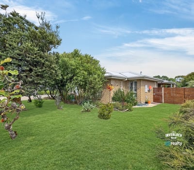 This inviting home features a spacious yard, surrounded by lush greenery and abundant natural light.