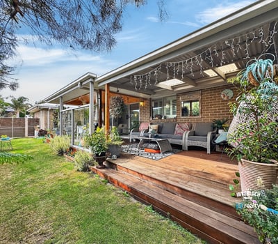 Spacious outdoor deck surrounded by lush gardens, perfect for entertaining or enjoying peaceful moments.