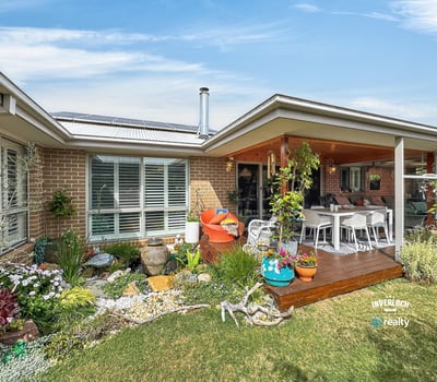 Inviting outdoor space featuring lush gardens and a spacious entertaining area, perfect for gatherings or relaxation.