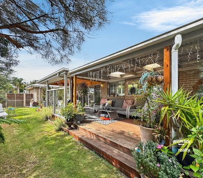 Spacious outdoor living area surrounded by lush landscaping, perfect for relaxation and entertaining.