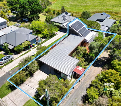 Discover a spacious home with unique architecture, surrounded by lush landscaping and ample outdoor space.