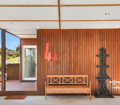 Modern entrance featuring a unique wooden design, inviting natural light and showcasing outdoor views.