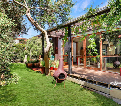 This unique property features a spacious outdoor area with lush greenery and inviting living spaces.