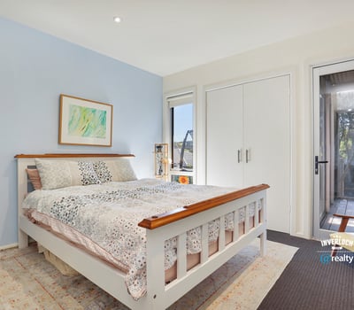 Bright bedroom featuring large windows, offering a peaceful atmosphere and easy access to outdoor living space.