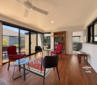 Bright, inviting sunroom featuring large windows, ideal for relaxation or entertaining in a cozy atmosphere.