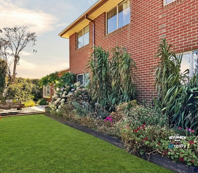 Well-maintained backyard surrounded by vibrant landscaping, perfect for outdoor gatherings or relaxing afternoons.
