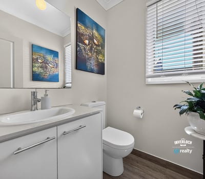 Modern bathroom featuring sleek fixtures, vibrant wall art, and ample natural light for a welcoming atmosphere.
