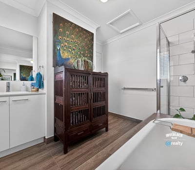 Contemporary bathroom featuring modern fixtures, natural light, and a unique wooden cabinet for added storage.