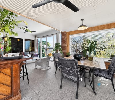 Bright and airy sunroom featuring ample greenery and spacious dining area for leisurely gatherings.