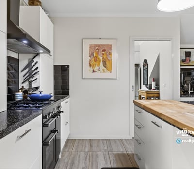 Modern kitchen featuring sleek appliances, ample counter space, and distinct artwork for a vibrant touch.