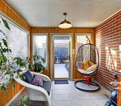 Bright sunroom featuring a cozy seating area and access to a beautifully landscaped outdoor space.
