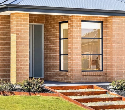 Contemporary brick home featuring unique architectural lines and a beautifully landscaped entryway.