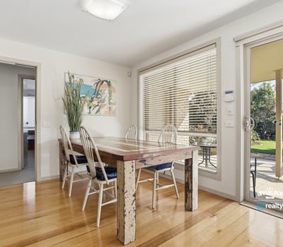 Bright dining area featuring large windows, a spacious table, and easy access to a private outdoor space.