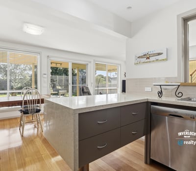 Bright and airy kitchen featuring modern finishes, large windows, and seamless access to outdoor dining.