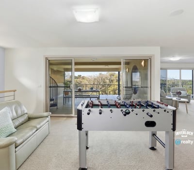 Spacious recreational area with a foosball table and large windows showcasing captivating outdoor views.
