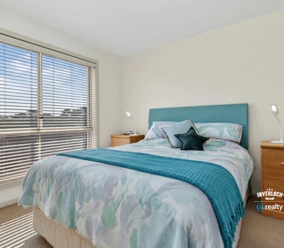 Bright bedroom featuring large windows, contemporary decor, and a cozy atmosphere, perfect for relaxation.