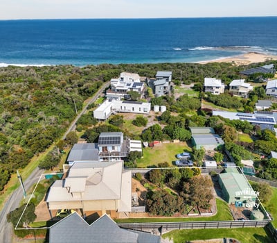 Stunning coastal property with expansive ocean views, surrounded by lush greenery and spacious outdoor areas.