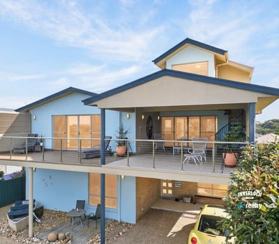 This contemporary home features spacious outdoor living areas and large windows that invite abundant natural light.