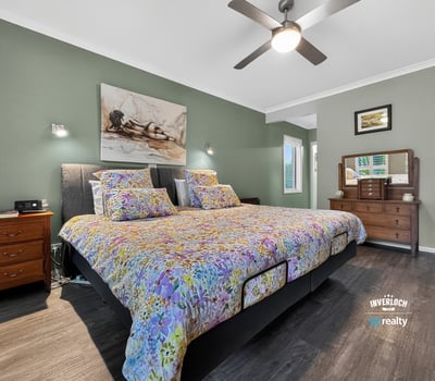 Spacious bedroom featuring a large bed, modern fixtures, and a calming color palette for relaxation.
