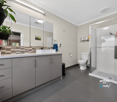 Spacious bathroom featuring modern finishes, a walk-in shower, and ample storage for everyday essentials.