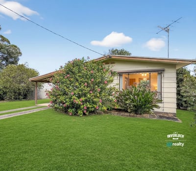 This inviting home features expansive gardens and a welcoming porch, perfect for outdoor relaxation and gatherings.