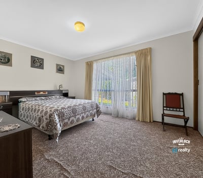 Spacious bedroom featuring large windows that invite natural light and offer a view of the garden.