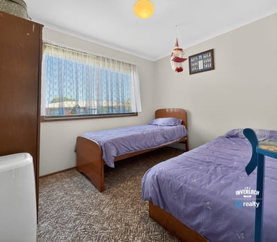 Bright and inviting bedroom featuring twin beds, large window, and ample natural light throughout.