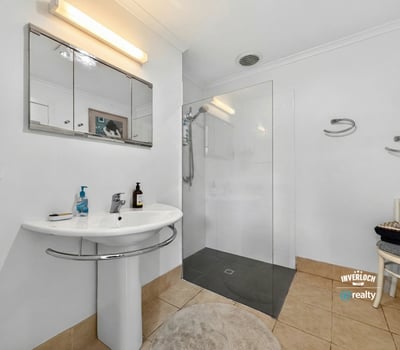 Modern bathroom featuring a glass shower, sleek fixtures, and ample natural light for a bright atmosphere.
