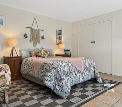 Cozy bedroom featuring botanical decor, abundant natural light, and ample storage for comfortable living.